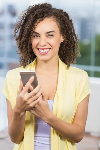 Femme d'affaires souriante tenant son téléphone — Photo