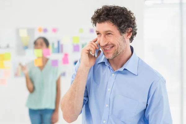 Businessman having phone call while his colleague posing — Stockfoto