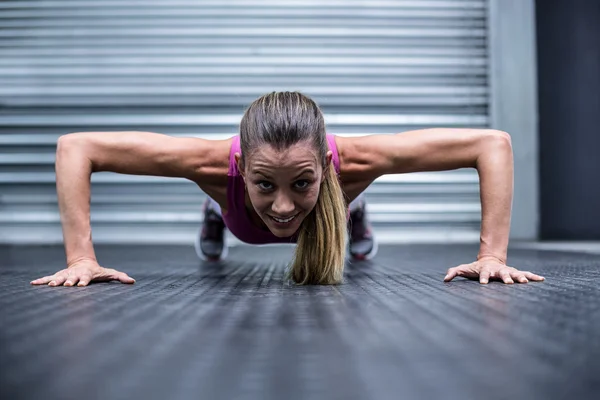 Gespierde vrouw doet push ups — Stockfoto