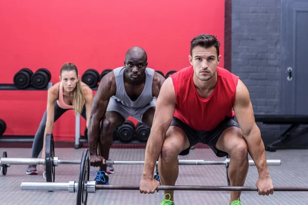Three muscular athletes lifting barbells — Stock Photo, Image