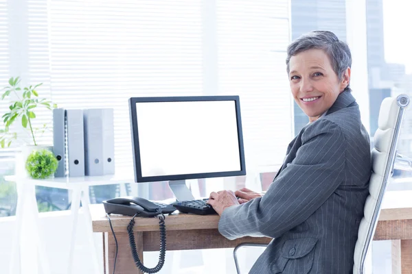 Glimlachende zakenvrouw met behulp van computer — Stockfoto