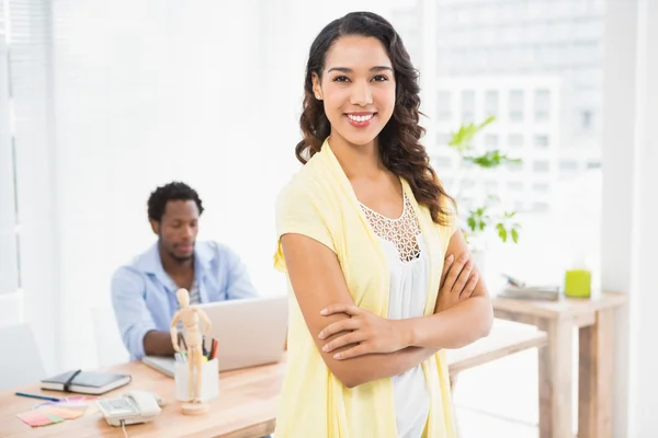 Smiling woman posing in front of her colleague with arms crossed — Stock Photo, Image