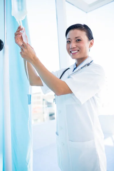 Female doctor connecting an intravenous drip — Stock Photo, Image