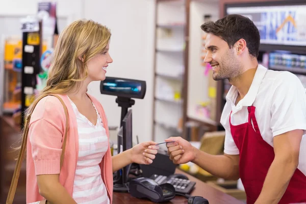 Woman at cash register paying with credit car — Stock Photo, Image