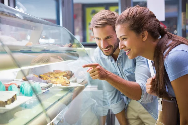 Happy couple choosing cake — ストック写真