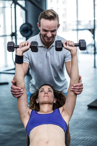 A muscular woman lifting dumbbells — Stock Photo, Image