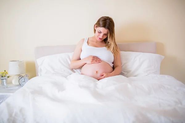 怀孕的女人看着她的肚子里 — 图库照片