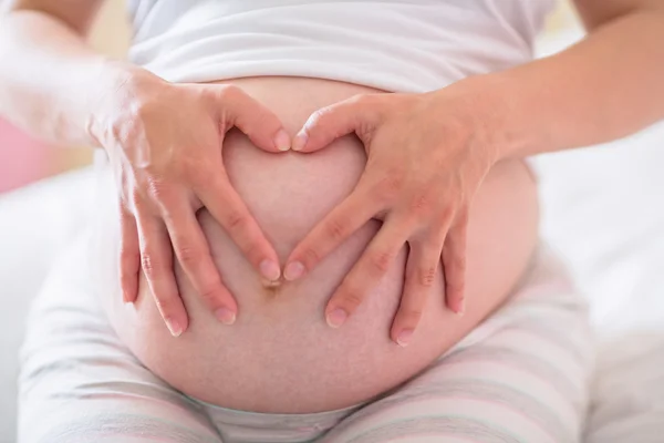 Pregnant woman holding her bump — Stock Photo, Image