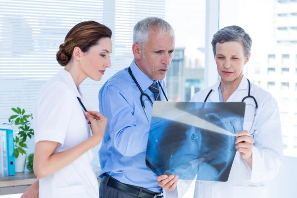 Colegas médicas concentradas examinando raios-X juntas — Fotografia de Stock