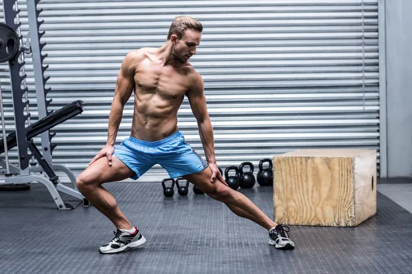 Muskulöser Mann macht Beinstreckungen — Stockfoto