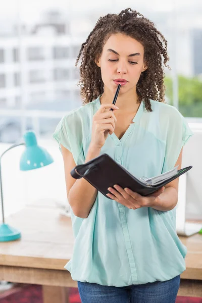 Pensativa mujer de negocios sosteniendo un cuaderno —  Fotos de Stock