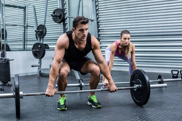 Couple musculaire soulevant le poids ensemble — Photo