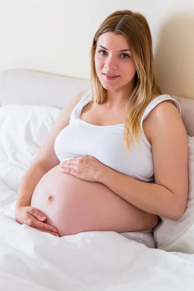 Zwangere vrouw kijken camera — Stockfoto