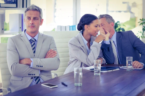 Triste uomo d'affari che guarda lontano mentre i suoi colleghi parlano — Foto Stock