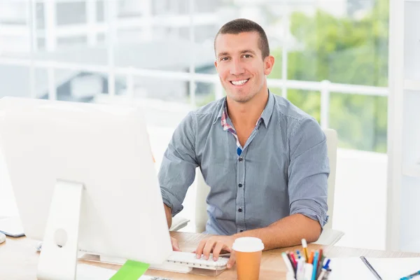 Красивый улыбающийся бизнесмен, печатающий на компьютере — стоковое фото