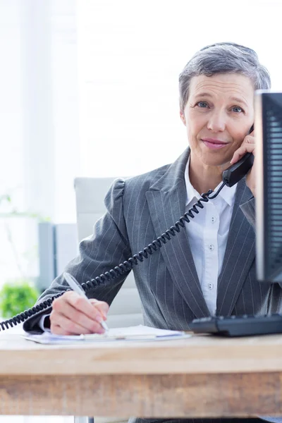 Retrato sonriente de una mujer de negocios llamando y escribiendo —  Fotos de Stock