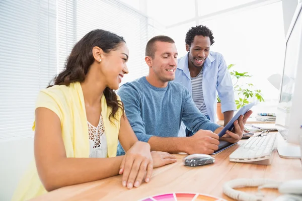 Colaboradores sorridentes usando o computador tablet juntos — Fotografia de Stock