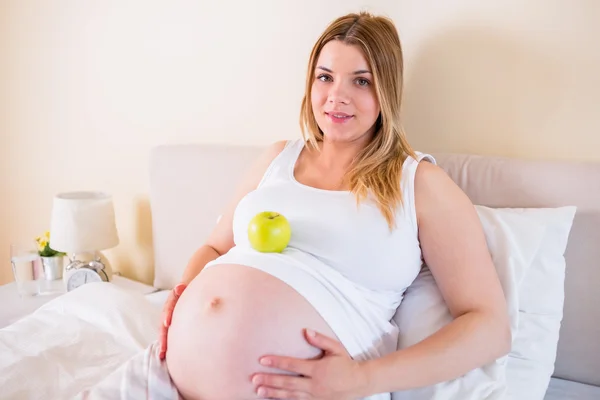 Kobieta w ciąży z apple w brzuch — Zdjęcie stockowe