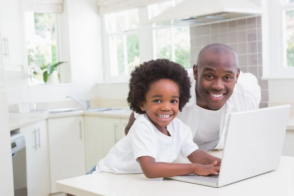 Père et fils utilisant un ordinateur portable sur le canapé — Photo