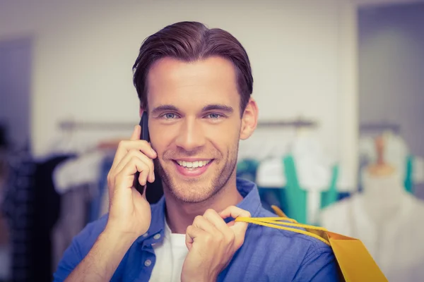 Un uomo sorridente con le borse della spesa che chiama — Foto Stock