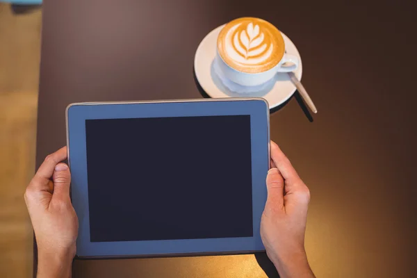 Digital tablet och kaffe på bordet — Stockfoto