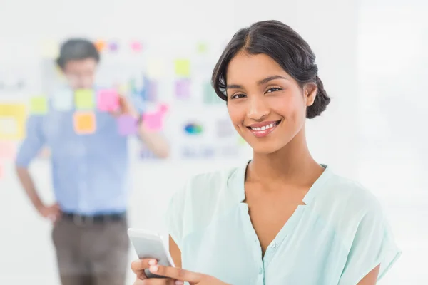 Businesswoman having phone call while her colleague posing — Stock fotografie