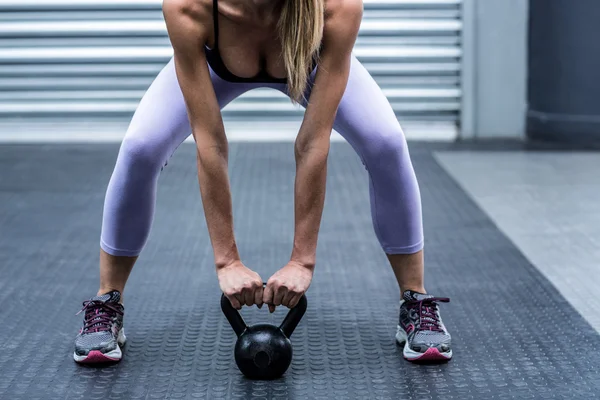 Vrouw opheffing kettlebells — Stockfoto