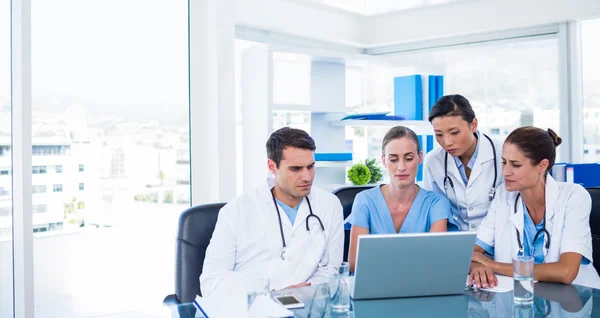 Equipo de médicos mirando el ordenador portátil — Foto de Stock