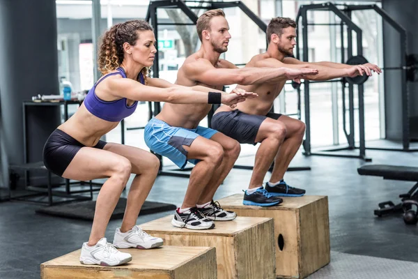 Atletas musculares haciendo sentadillas de salto — Foto de Stock