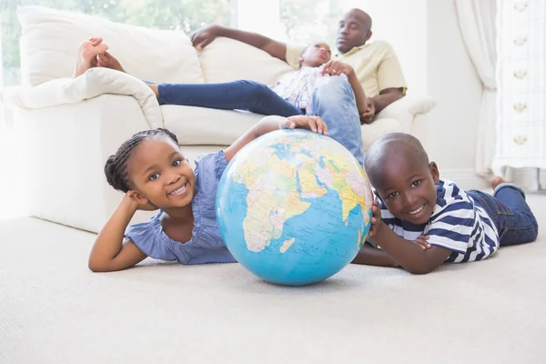 Happy siblings using their globe — Stock Photo, Image