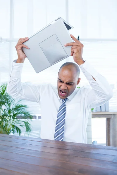 Irritierter Geschäftsmann vor dem Zerbrechen seines Laptops — Stockfoto