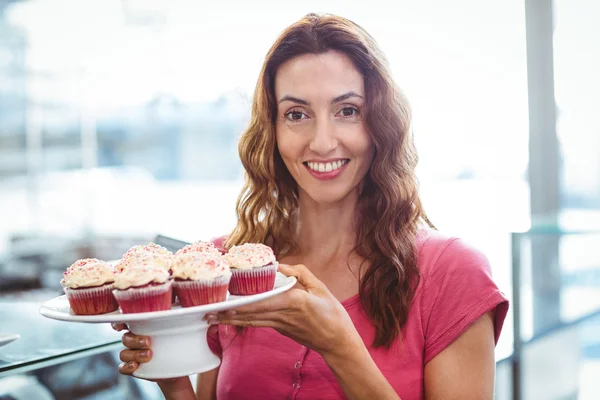 Brunette showing plate of pastries — Stock Photo, Image