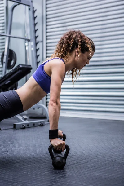 Mujer muscular haciendo flexiones con pesas —  Fotos de Stock