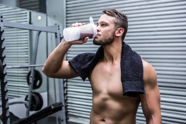 Мускулистый человек пьет протеиновый коктейль — стоковое фото