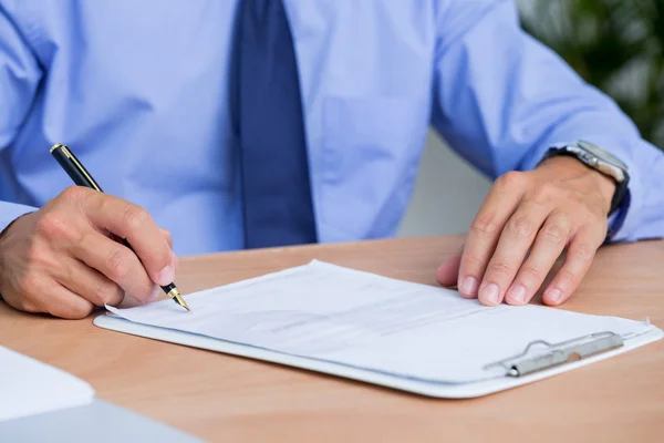 Businessman signing a contract in the office Royalty Free Stock Photos