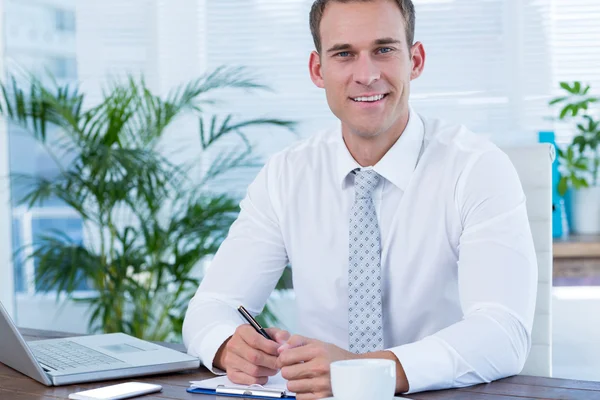 Smiling businessman writing on notebook Royalty Free Stock Images