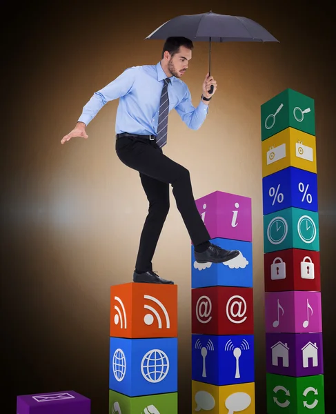 Businessman holding umbrella and balancing — Stock Photo, Image