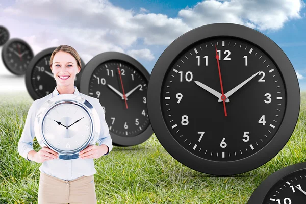 Businesswoman in suit holding a clock — Stock Photo, Image