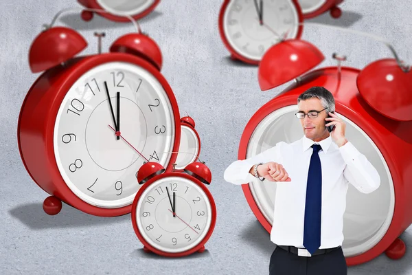 Empresario en el teléfono mirando el reloj de pulsera — Foto de Stock