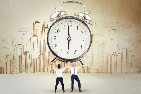 Businessmen holding alarm clock — Stock Photo, Image