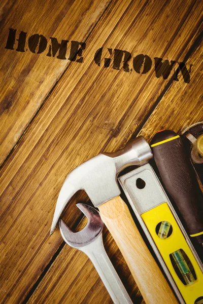 Palavra casa crescida contra ferramentas — Fotografia de Stock