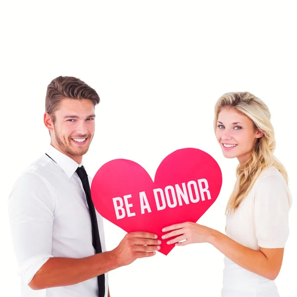 Attractive young couple holding red heart — Stock Photo, Image