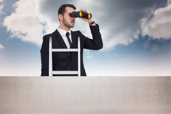 Composite image of businessman looking on a ladder — Stock Photo, Image