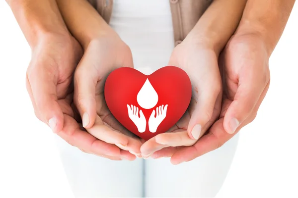 Couple holding miniature heart in hands — Stock Photo, Image