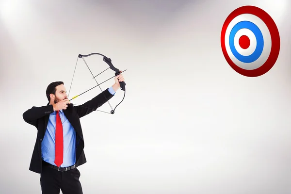 Businessman shooting bow and arrow — Stock Photo, Image
