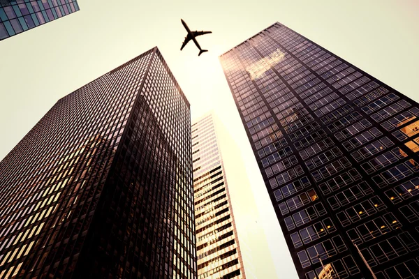 Avião voador e arranha-céus — Fotografia de Stock
