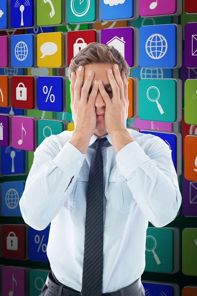 Businessman with a headache against green — Stock Photo, Image