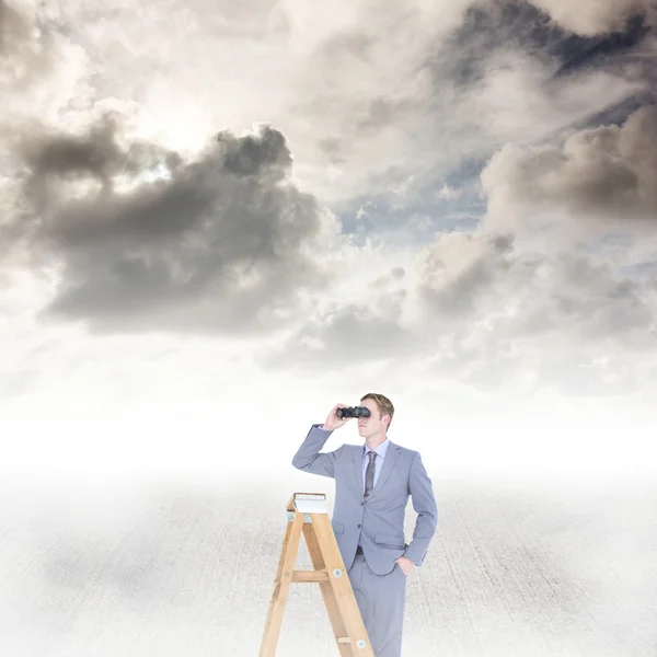 Businessman looking on ladder and using binoculars — Stock Photo, Image