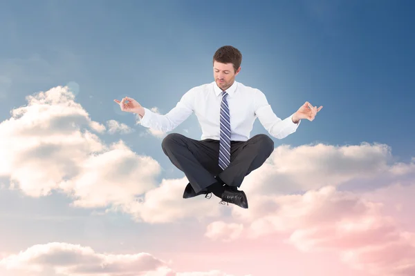 Businessman meditating in lotus pose — Stock Photo, Image