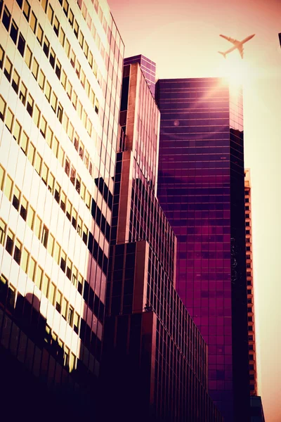 Flying airplane and skyscrapers — Stock Photo, Image